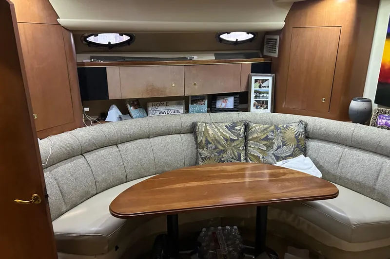 Slide: The Image of Interior of 1998 Cruisers Yachts 4270 Express with cozy seating and wooden table. - 10