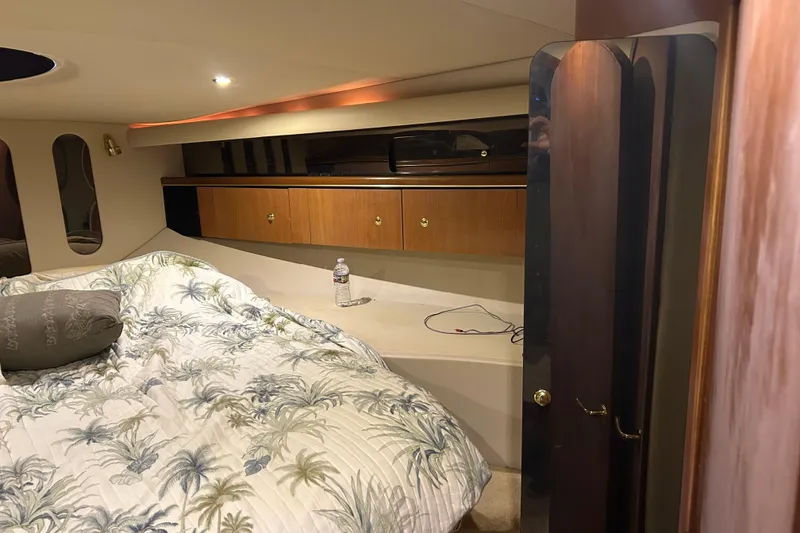 Slide: The Image of 1998 Cruisers Yachts 4270 Express cabin interior with bed and wooden cabinets. - 5