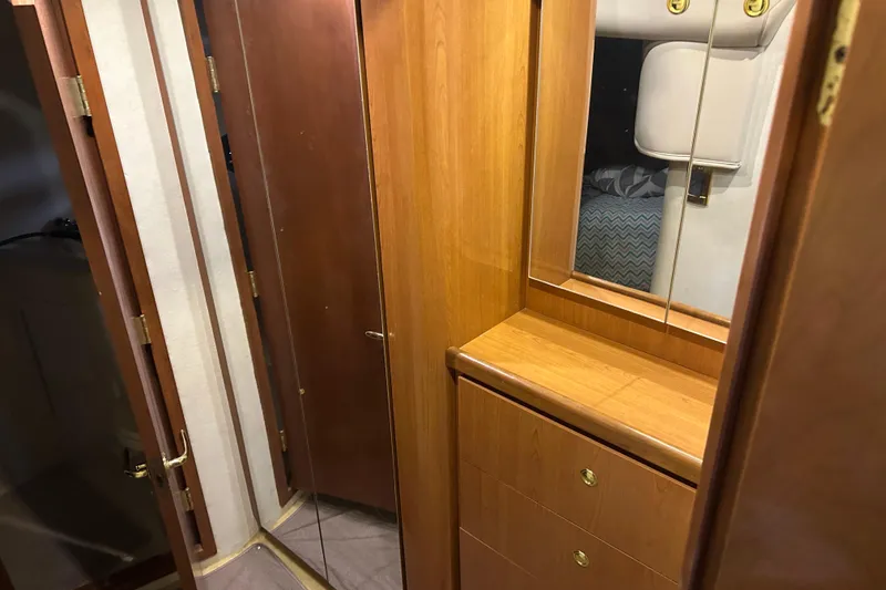 Slide: The Image of 1998 Cruisers Yachts 4270 Express interior with wooden cabinetry and mirrored accents. - 11