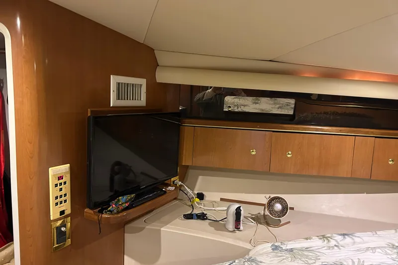 Slide: The Image of Interior of 1998 Cruisers Yachts 4270 Express with TV and wooden cabinetry. - 4
