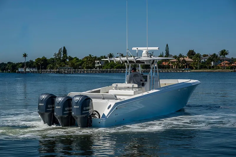 Slide: The Image of 2017 Venture 39 Open boat cruising on a calm lake with triple Yamaha engines. - 14