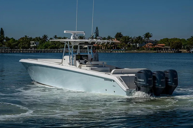 Slide: The Image of 2017 Venture 39 Open boat cruising on a calm waterway with triple Yamaha engines. - 17