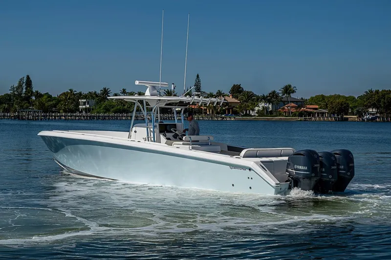 Slide: The Image of 2017 Venture 39 Open boat cruising on a calm waterway with triple Yamaha engines. - 18