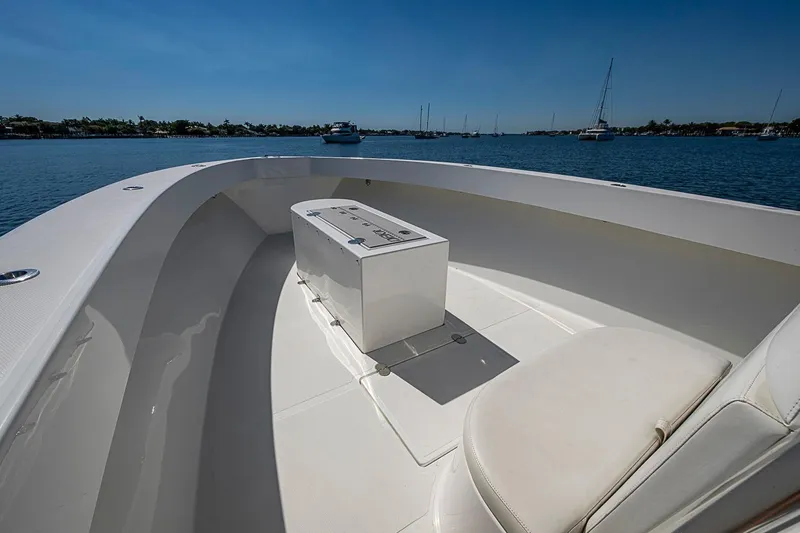 Slide: The Image of 2017 Venture 39 Open boat interior with seating and storage, on calm water. - 20