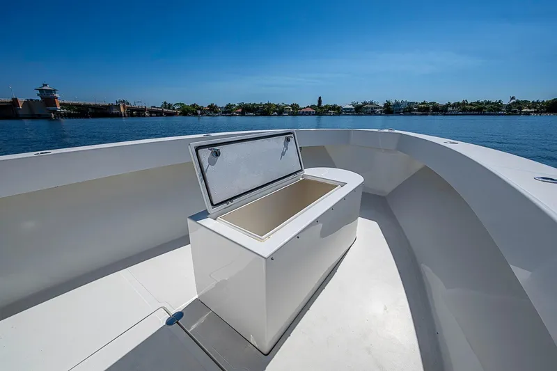 Slide: The Image of 2017 Venture 39 Open boat with open storage compartment, docked near a scenic waterfront. - 25