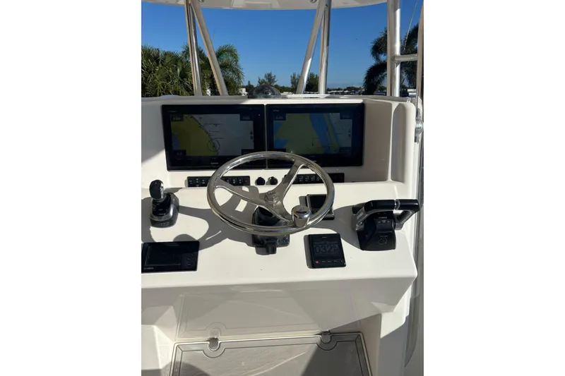 Slide: The Image of 2017 Venture 39 Open boat helm with dual navigation screens and steering wheel. - 3
