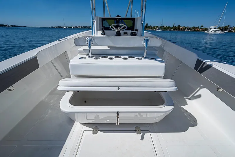 Slide: The Image of 2017 Venture 39 Open boat interior with seating and storage, on calm water. - 39