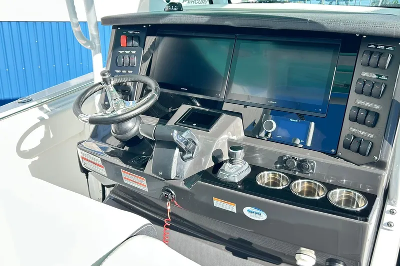 Slide: The Image of 2023 Blackfin 332 CC boat dashboard with dual screens and steering wheel. - 10