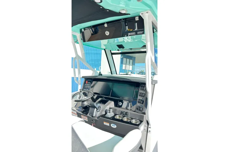 Slide: The Image of 2023 Blackfin 332 CC boat helm with modern controls and steering wheel. - 13