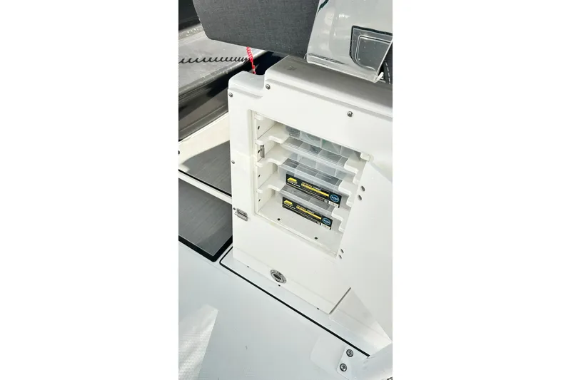 Slide: The Image of 2023 Blackfin 332 CC boat storage compartment with organized tackle boxes. - 23