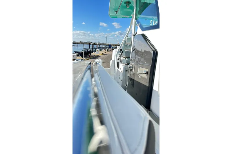 Slide: The Image of 2023 Blackfin 332 CC boat docked at a marina under a clear blue sky. - 29