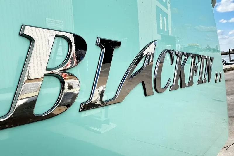 Slide: The Image of Close-up of 2023 Blackfin 332 CC boat logo on a light blue hull. - 3