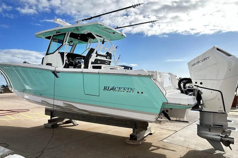 Slide: The Image of 2023 Blackfin 332 CC boat with Mercury engine, docked under a clear blue sky. - 4