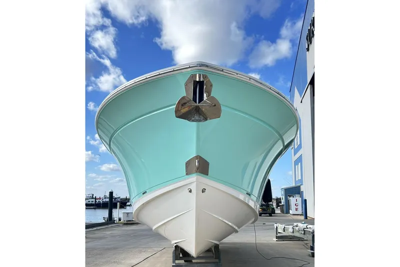 Slide: The Image of 2023 Blackfin 332 CC boat with a sleek hull design, docked under a blue sky. - 6