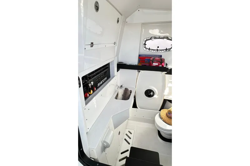 Slide: The Image of Interior of 2023 Blackfin 332 CC boat, featuring control panel and storage area. - 62