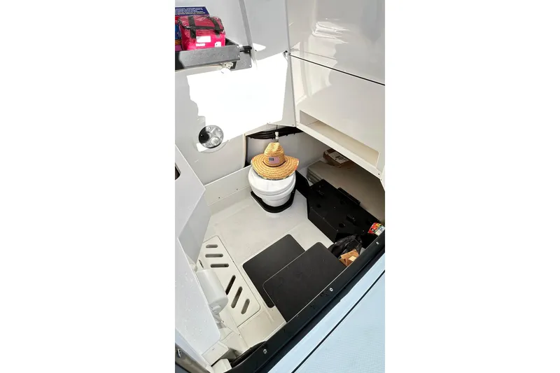 Slide: The Image of 2023 Blackfin 332 CC boat interior with a compact restroom and storage area. - 63