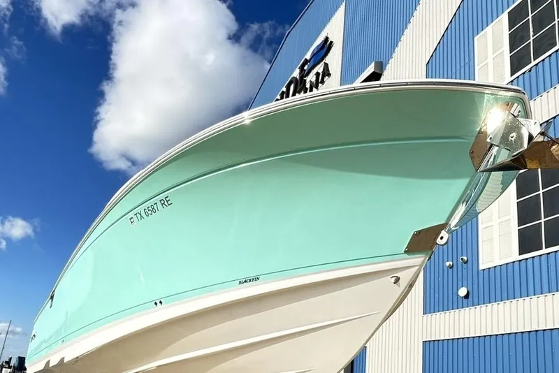 Slide: The Image of 2023 Blackfin 332 CC boat against blue sky and building background. - 7