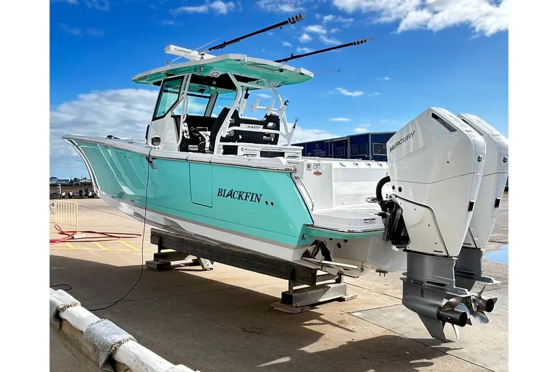 Slide: The Image of 2023 Blackfin 332 CC boat with dual Mercury engines on a dock. - 71
