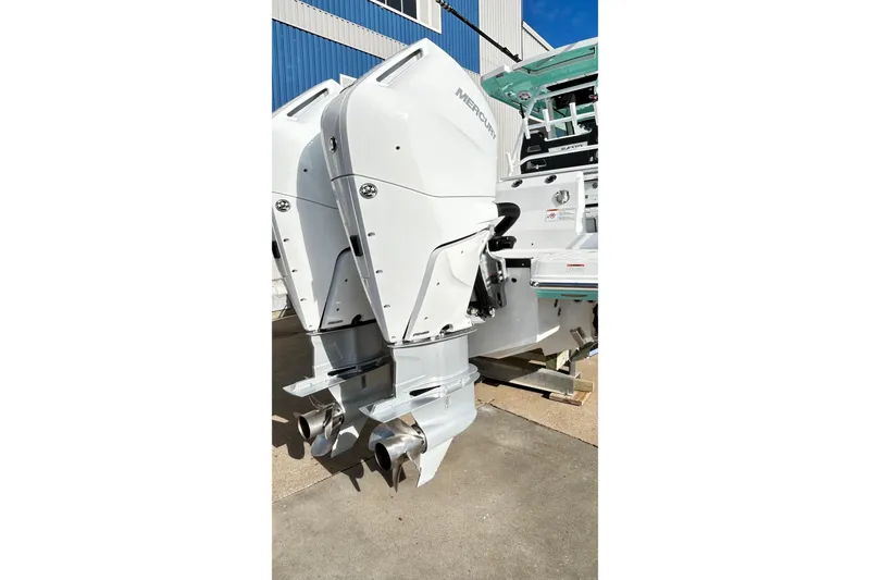 Slide: The Image of 2023 Blackfin 332 CC boat with dual Mercury outboard engines, docked outdoors. - 73