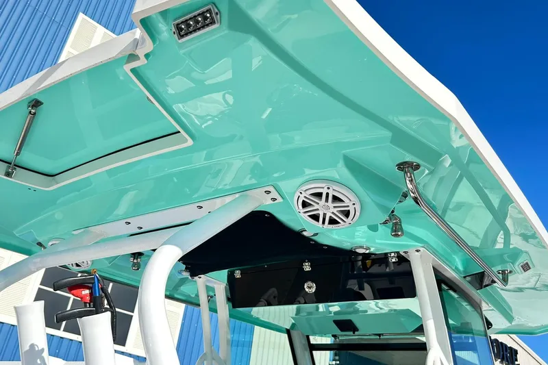 Slide: The Image of 2023 Blackfin 332 CC boat with teal hardtop and speaker system. - 8