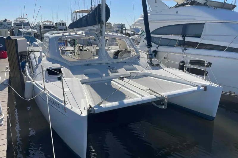The Image of 1998 Maine Cat Catamaran docked at marina, surrounded by other boats. - 0