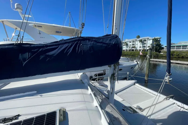 Slide: The Image of 1998 Maine Cat Catamaran docked in a sunny marina, featuring sails and rigging. - 12