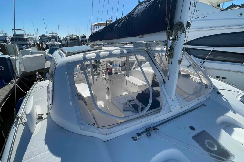 Slide: The Image of 1998 Maine Cat Catamaran docked at marina, featuring spacious cockpit and clear canopy. - 15