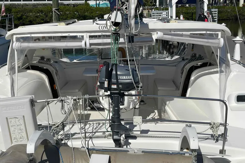 Slide: The Image of 1998 Maine Cat Catamaran with Yamaha motor, docked at marina. - 2