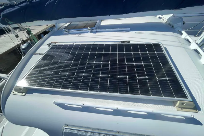 Slide: The Image of 1998 Maine Cat Catamaran with solar panel, docked at marina under clear blue sky. - 22