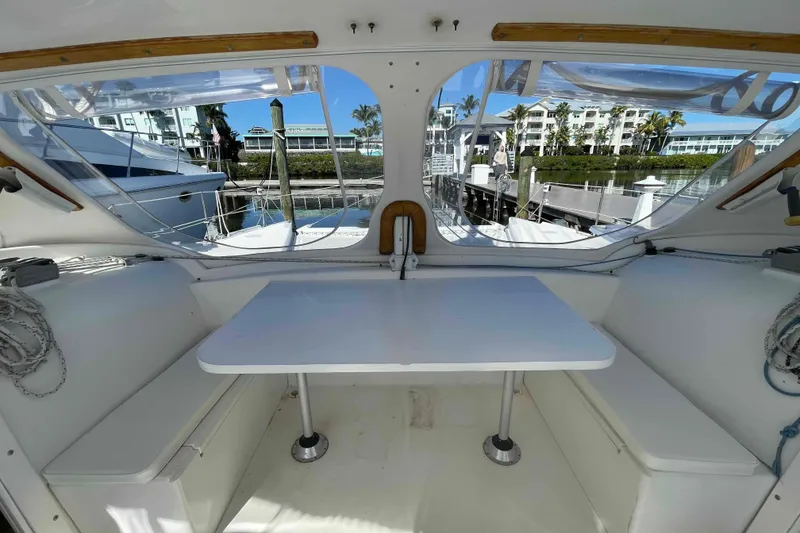 Slide: The Image of 1998 Maine Cat Catamaran interior with table, docked at marina, sunny day. - 4