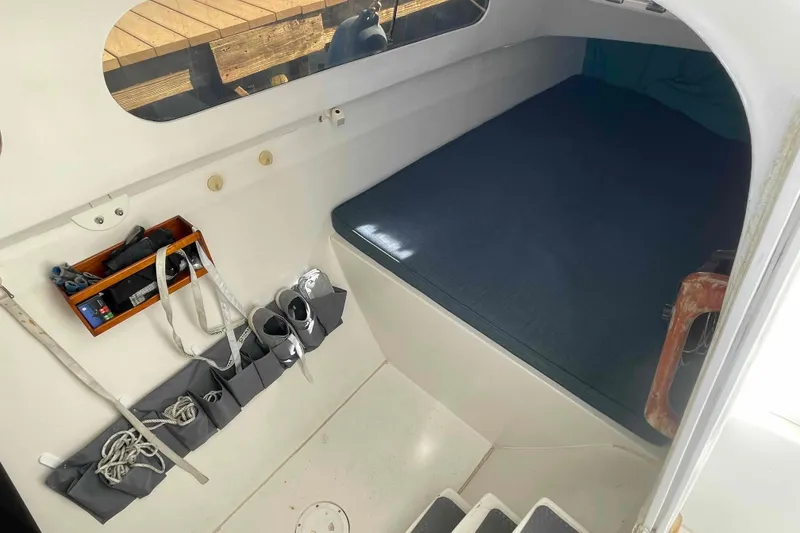 Slide: The Image of Storage setup on a 1998 Maine Cat Catamaran with ropes, shoes, and accessories. - 44