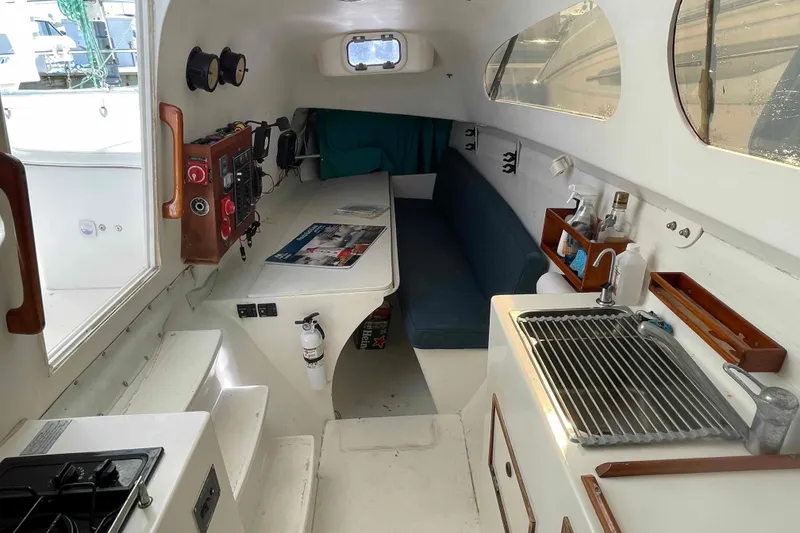 Slide: The Image of Interior of a 1998 Maine Cat Catamaran featuring a compact kitchen and seating area. - 5