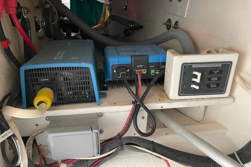 Slide: The Image of Control panel of a 1998 Maine Cat Catamaran with various switches and gauges. - 52