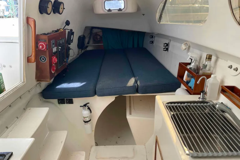 Slide: The Image of Interior of a 1998 Maine Cat Catamaran with bed, control panel, and kitchenette. - 6