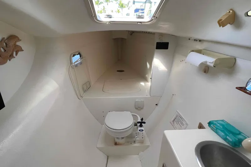 Slide: The Image of 1998 Maine Cat Catamaran interior with cushioned seating and storage compartment. - 66