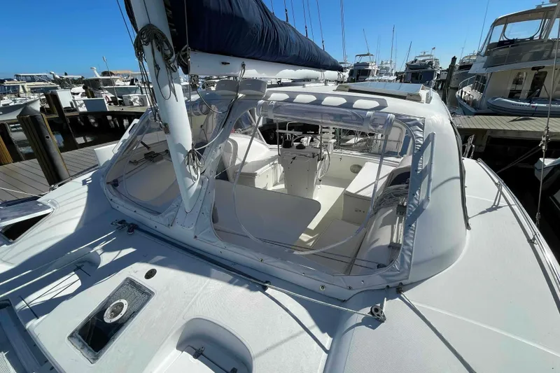 Slide: The Image of 1998 Maine Cat Catamaran with open cockpit and steering wheel, docked under clear blue sky. - 68