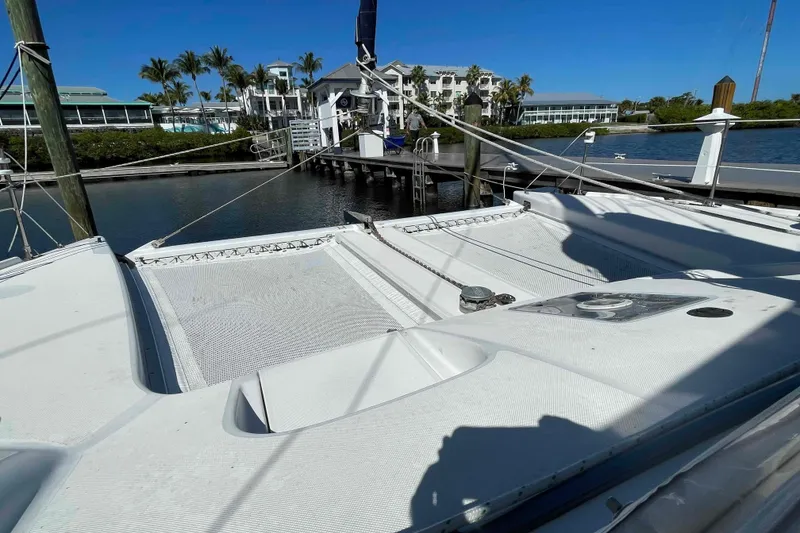 Slide: The Image of 1998 Maine Cat Catamaran docked at marina, showcasing cockpit and sail. - 69
