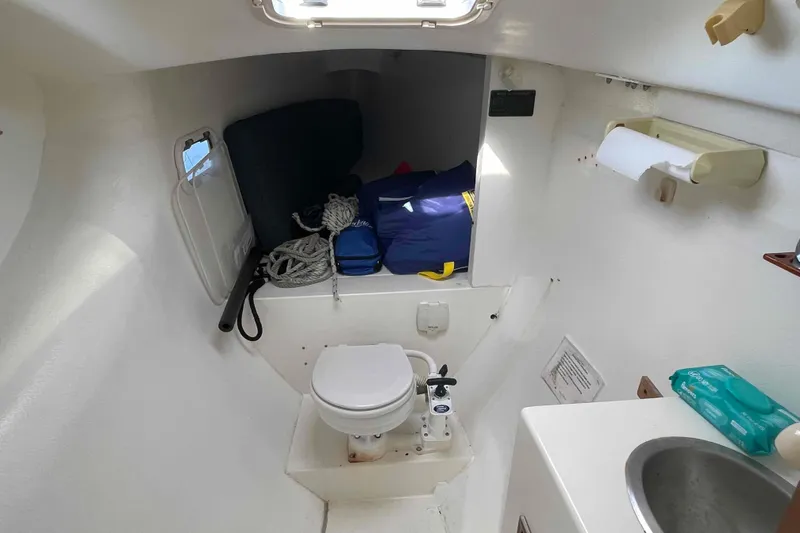 Slide: The Image of 1998 Maine Cat Catamaran bathroom with toilet, sink, storage, and nautical equipment. - 8