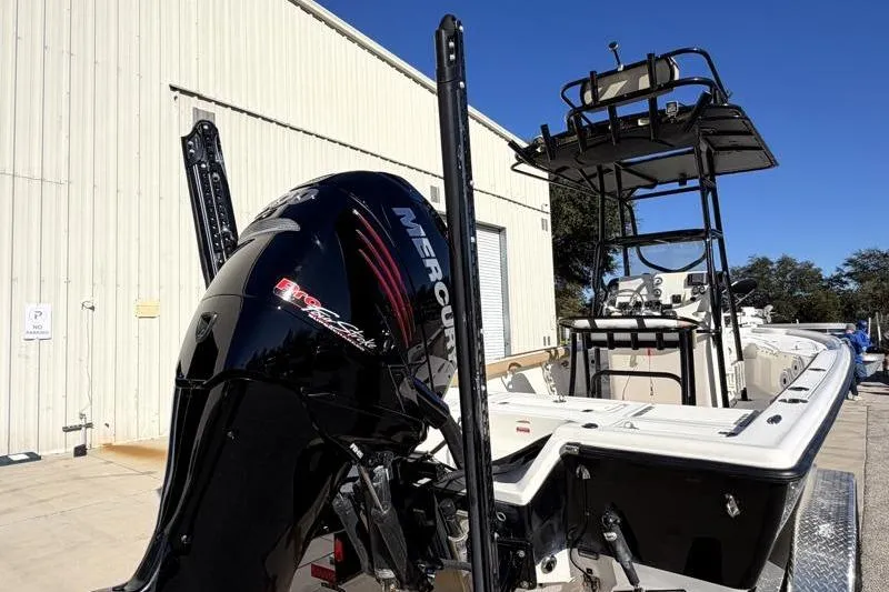Slide: The Image of 2016 Key West 230 Bay Reef boat with Mercury engine, docked near a warehouse. - 17