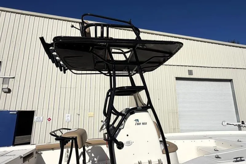 Slide: The Image of 2016 Key West 230 Bay Reef boat with tower, parked near a warehouse. - 19