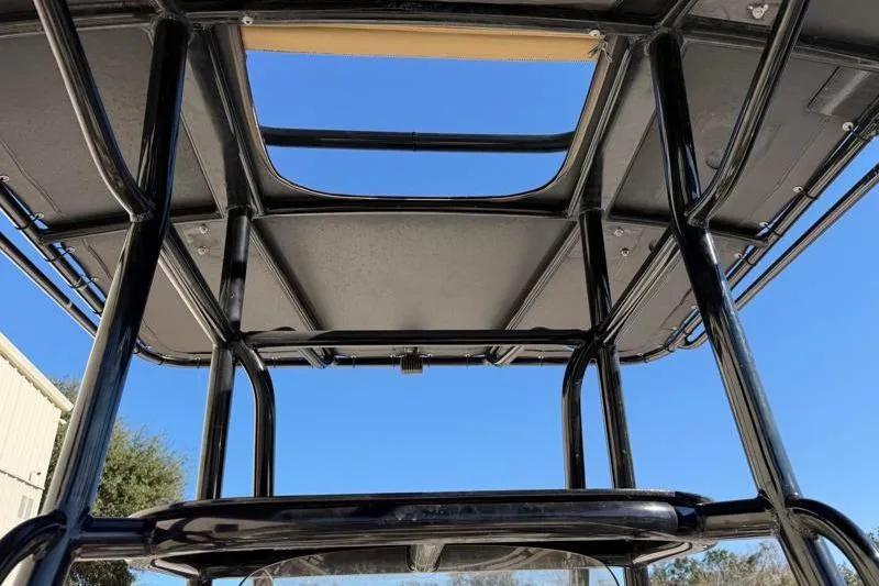 Slide: The Image of T-top structure of a 2016 Key West 230 Bay Reef boat against a clear blue sky. - 36