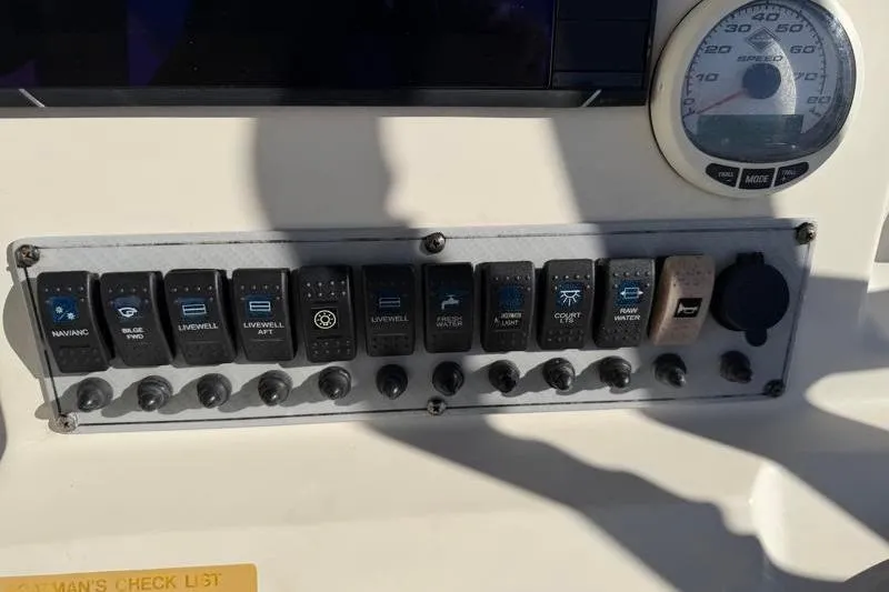 Slide: The Image of Control panel of a 2016 Key West 230 Bay Reef boat with various switches and a gauge. - 42