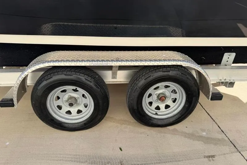 Slide: The Image of Trailer wheels of a 2016 Key West 230 Bay Reef boat on pavement. - 56