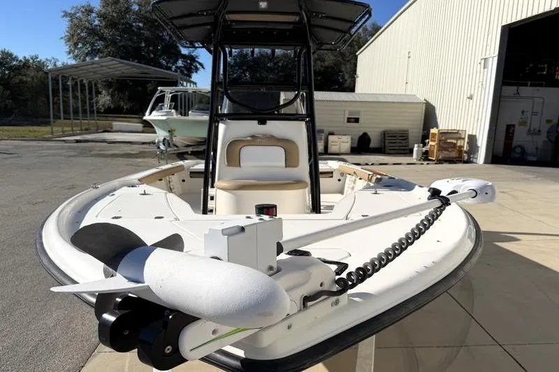 Slide: The Image of 2016 Key West 230 Bay Reef boat with trolling motor, parked near a warehouse. - 6