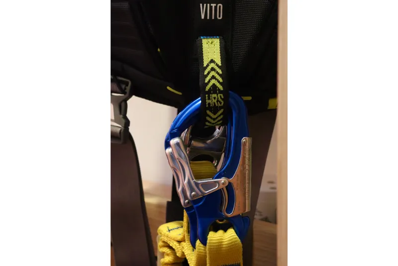 Slide: The Image of Safety harness with blue carabiner and yellow strap, labeled "Vito" and "HRS." - 104