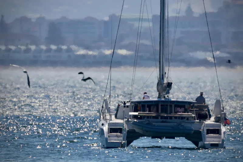 Slide: The Image of Outremer 51 catamaran sailing on shimmering water, 2017 model, with seagulls flying nearby. - 131