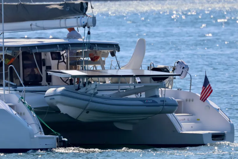 Slide: The Image of 2017 Outremer 51 catamaran with dinghy and American flag on water. - 133