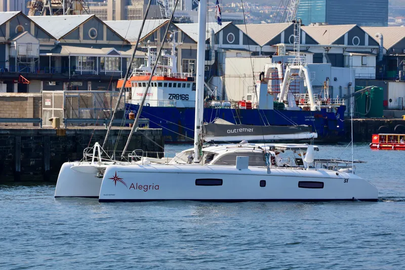 Slide: The Image of 2017 Outremer 51 catamaran "Alegria" docked in a bustling harbor. - 138