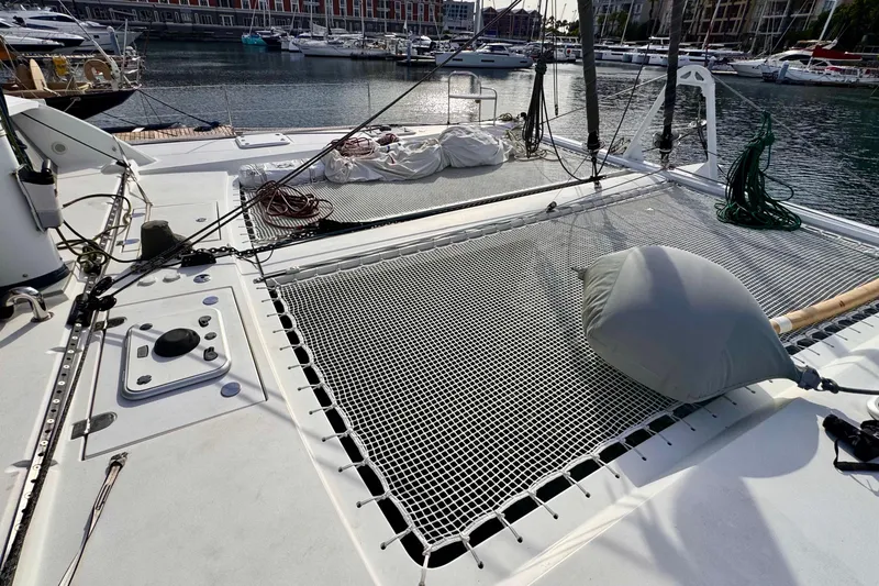 Slide: The Image of Deck view of 2017 Outremer 51 catamaran with netting and marina background. - 23
