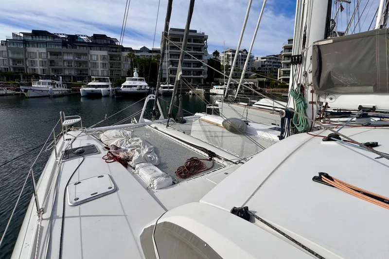 Slide: The Image of 2017 Outremer 51 catamaran docked in a marina with modern buildings in the background. - 25